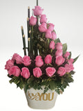 Impresionante arreglo floral compuesto por impactantes rosas en tonos rosas. Le quieres expresar tu profundo y enorme amor? Este es el regalo que nunca olvidará!Incluye tarjeta para mensaje. Especificaciones del Arreglo: Follaje, Incluye Mensaje impreso, Base metálica color blanca con diseño LOVE YOU, Altura promedio del arreglo: 55 cm