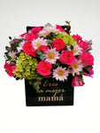 Sorprende a mamá con una elegante caja llena de hermosas rosas de color súper alegre y brillante! Sin duda un regalo súper trendy y de alto impacto. Arreglo con vista frontal elaborada con base cúbica metálica color negro brillante de 20 cm con letrero “Eres la mejor mamá”. Altura final promedio: 40 cms. El tono de las flores puede variar de acuerdo a la disponibilidad. Incluye tarjeta para mensaje.