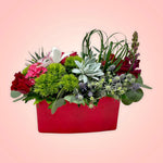 Un arreglo con un original e inesperado diseño floral, será la sorpresa perfecta para el Día de San Valentín!  ENVÍO GRATIS:  ESPECIFICACIONES DEL ARREGLO:  Arreglo en forma rectangular compuesto por rosas en intenso color rojo, originales suculentas, un discreto detalle de follaje en forma de corazón y el toque súper elegante de una increíble orquídea cultivada! Base rectangular color roja Incluye tarjeta para dedicatoria Altura aproximada  35 cms