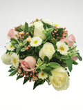 Coqueto arreglo floral compuesto por hermosas rosas, en tonos rosa y blanco acompañadas por margaritas que logran un efecto de gran sutileza. Recomendado para demostrar un amor lleno de ternura y romanticismo.  Especificaciones del Arreglo: Follaje, Cilindro de vidrio color rosa tornasol Incluye Mensaje impreso, Altura promedio del arreglo: 30 - 35 cm.