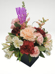 Lindo arreglo floral tamaño "petite" compuesto por rosas y claveles en tonos rosa. Es el diseño ideal combinarlo con otras sorpresas!  ESPECIFICACIONES DEL ARREGLO:  Follaje Cubo de madera Incluye dedicatoria Altura promedio del arreglo: 30 cm