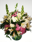 Delicado arreglo floral compuesto por delicadas rosas blancas, lirios y boca de dragón, con toques de follaje en color rosa para dar un efecto de delicadeza y elegancia. Recomendado para enviar un mensaje de sinceridad y amistad!. Especificaciones del Arreglo: Follaje. Cilindro de cristal. Mensaje impreso. Altura promedio del arreglo: 40 - 45 cm.