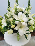 Discreto y elegante arreglo floral podrá hacer llegar como un mensaje de solidaridad a esa persona que desea acompañar. Arreglo con rosas blancas y casablancas. Sensibles a lo delicado de estos momentos; te invitamos a hacerte presente a través de este arreglo floral. Arreglo en maceta blanca de cerámica con rosas blancas, casablancas y follaje en tonos verde. Medidas aproximadas: Altura promedio: 45 cm. Ancho promedio: 38 cm. El tono de las flores puede variar de acuerdo a la disponibilidad.