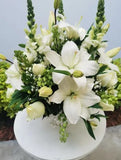 Discreto y elegante arreglo floral podrá hacer llegar como un mensaje de solidaridad a esa persona que desea acompañar. Arreglo con rosas blancas y casablancas. Sensibles a lo delicado de estos momentos; te invitamos a hacerte presente a través de este arreglo floral. Arreglo en maceta blanca de cerámica con rosas blancas, casablancas y follaje en tonos verde. Medidas aproximadas: Altura promedio: 45 cm. Ancho promedio: 38 cm. El tono de las flores puede variar de acuerdo a la disponibilidad.