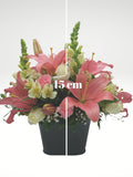 Sofisticado arreglo floral compuesto por hermosas rosas blancas, lilies rosas, lirios y boca de dragón para dar un toque de glamour y elegancia. Es una opción ideal para enviar un regalo a una persona con estilo. Base metálica color negro, Incluye mensaje impreso, Altura promedio del arreglo: 45 cm