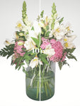 Delicado arreglo floral compuesto por delicadas rosas blancas, lirios y boca de dragón, con toques de follaje en color rosa para dar un efecto de delicadeza y elegancia. Recomendado para enviar un mensaje de sinceridad y amistad!. Especificaciones del Arreglo: Follaje. Cilindro de cristal. Mensaje impreso. Altura promedio del arreglo: 40 - 45 cm.