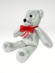DESCRIPCIÓN: Esta Navidad será Inolvidable para tu persona favorita con este increíble Oso Navideño artesanal. Está hecho a mano con una hermosa tela bordada con lentejuelas en color plata y decorado con un coqueto moño de organza rojo!  ESPECIFICACIONES DEL MUÑECO:  Tamaño: 48 cm de altura