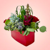 Un arreglo con un original e inesperado diseño floral, será la sorpresa perfecta para el Día de San Valentín!  ENVÍO GRATIS:  ESPECIFICACIONES DEL ARREGLO:  Arreglo en forma rectangular compuesto por rosas en intenso color rojo, originales suculentas, un discreto detalle de follaje en forma de corazón y el toque súper elegante de una increíble orquídea cultivada! Base rectangular color roja Incluye tarjeta para dedicatoria Altura aproximada  35 cms