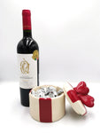 Original set con bombonera de edición limitada con diseño súper original y botella de vino tinto que seguramente causará un efecto “WOW!” a quién lo destino! Especificaciónes del Set: Bombonera de cerámica decorada en color rojo y crema. Chocolates de importación marca Sabor italiano o similar. Exclusiva Botella de Vino tinto de 750 ml marca Cava Quintanilla Reserva Syrah con Medalla de Oro Selección 2019. Incluye Mensaje impreso. Altura promedio de la bombonera: 16 cm